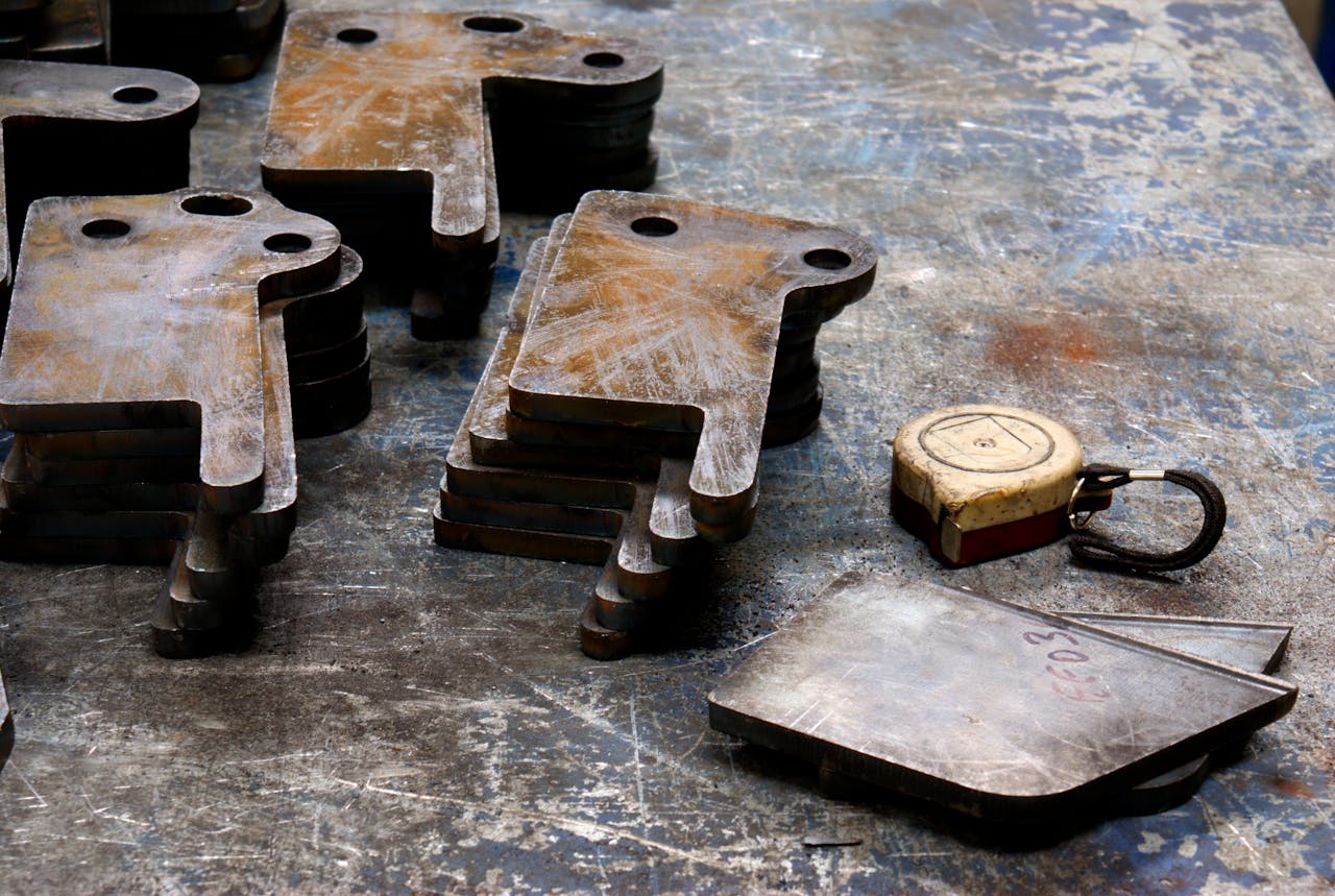 services-02 Rusted metal pieces with measuring tape on a scratched industrial surface.
